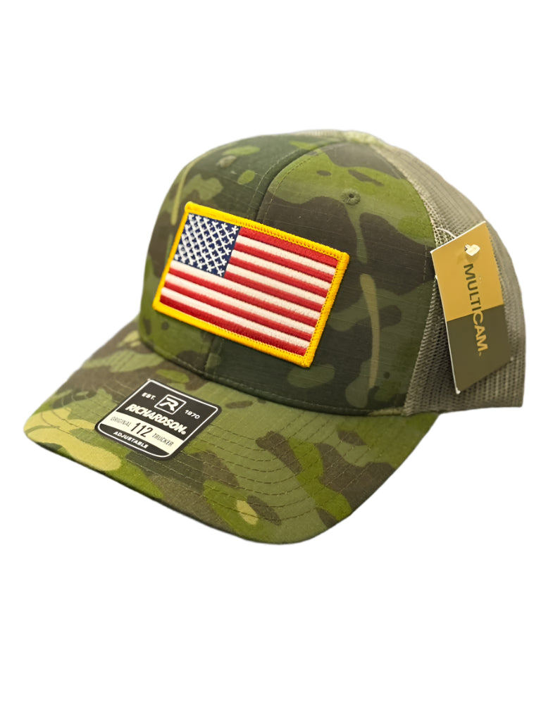 Camouflage cap with American flag patch on a textured surface