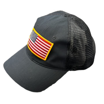 Black mesh cap with American flag patch on a textured surface