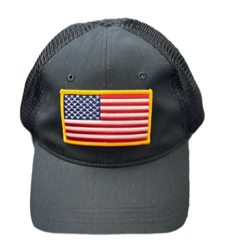 Black cap with American flag patch on a textured surface
